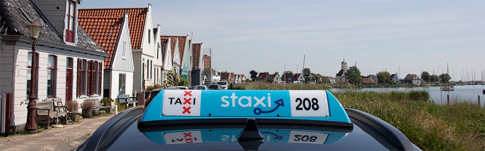 Image for Taxi Amsterdam - A Staxi Taxi in Amsterdam, with blue roof light saying Staxi with three red Amsterdam crosses.